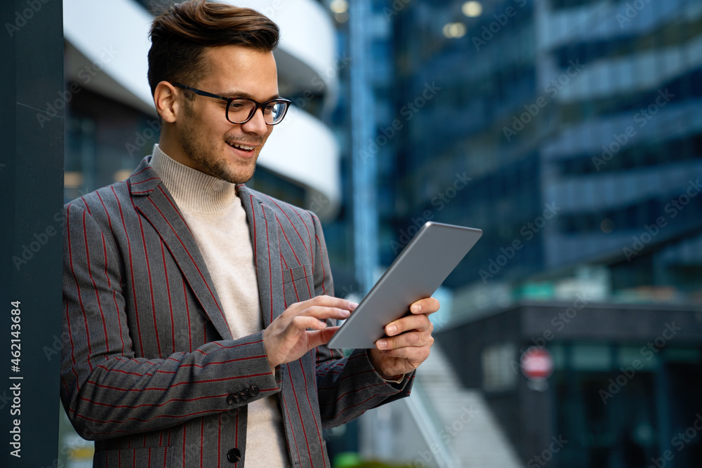 Fototapeta premium Portrait of successful man using digital tablet in urban background. Business people concept