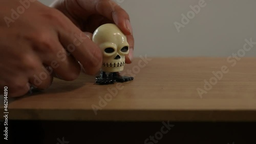 young man winding up  wind-up toy skull jumping