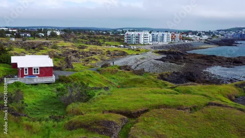 Rugged Terrain And High-Rise Buildings At The Seafront In Gardabaer, Iceland. aerial photo