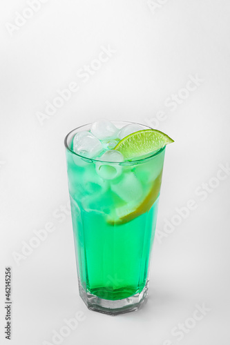 beautiful transparent glass of summer drink. green lemonade with ice and lime isolated on a white background with natural shadows