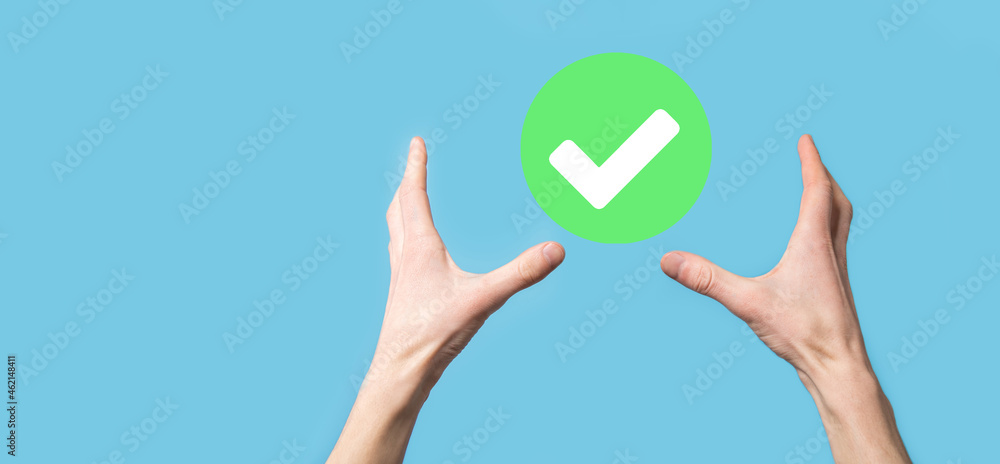 Hand holds green icon Check mark,Check Mark Sign, Tick Icon,right sign,circle green checkmark button,Done.On dark background.Banner.Copy space.Place for text. Hand holds green icon Check mark,Check Mark Sign, Tick Icon,right sign,circle green checkmark button,Done.On dark background.Banner.Copy space.Place for text.