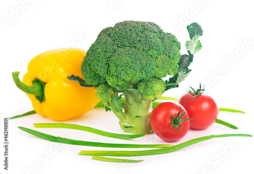 Vegetables on the white background - broccoli, tomatoes, cucumbers and green onions. Composition of vegetables on the white background