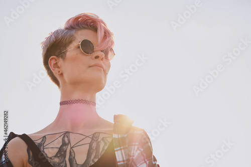 Portrait of young woman in round glasses on the ground