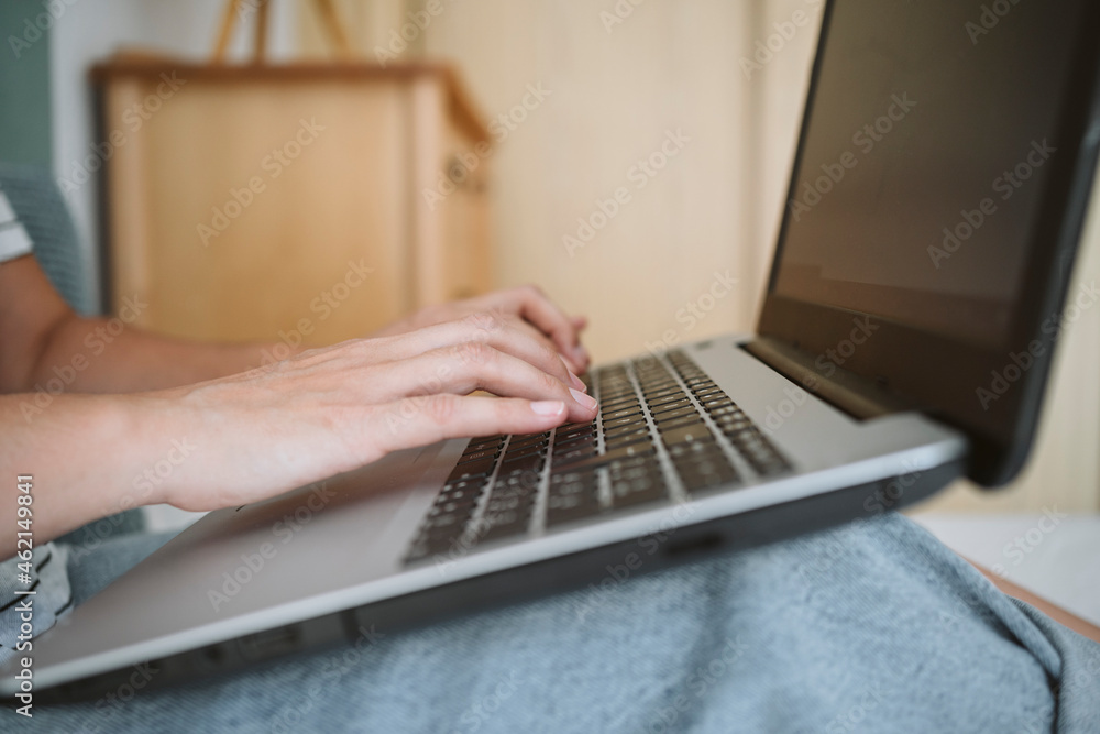 Woman typing while using laptop at home Woman typing while using laptop at home