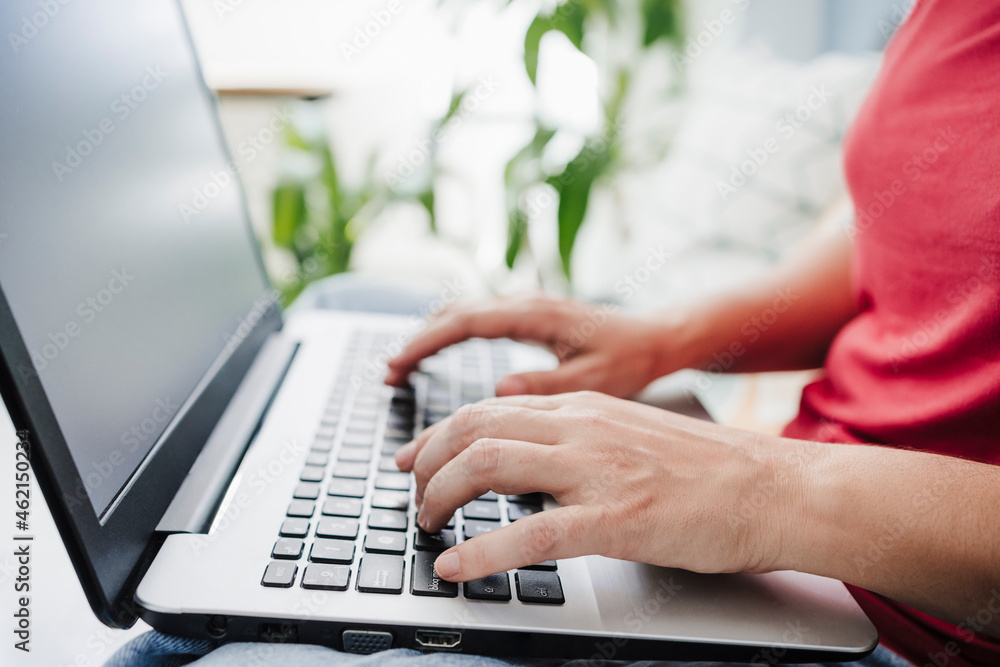 Woman typing while using laptop at home Woman typing while using laptop at home