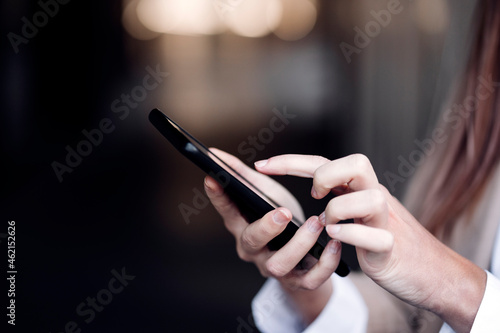 Young businesswoman text messaging through smart phone photo