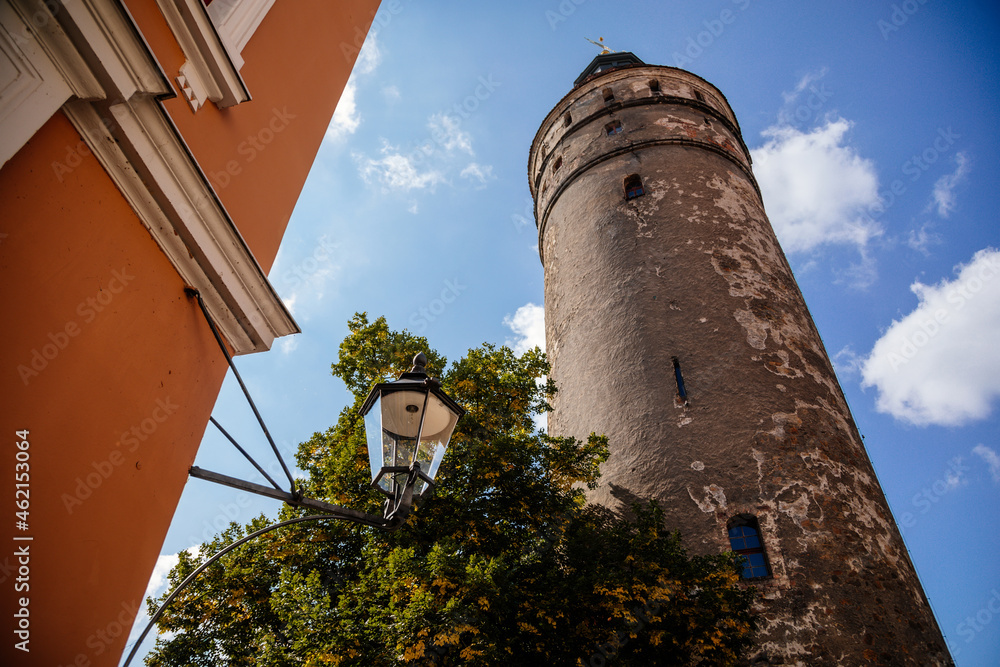 Goerlitz, Saxony, Germany, 04 September 2021: gothic renaissance massive Nikolaiturm or Nikolai Tower, historical center of old town, part of medieval fortification, narrow street at sunny summer day