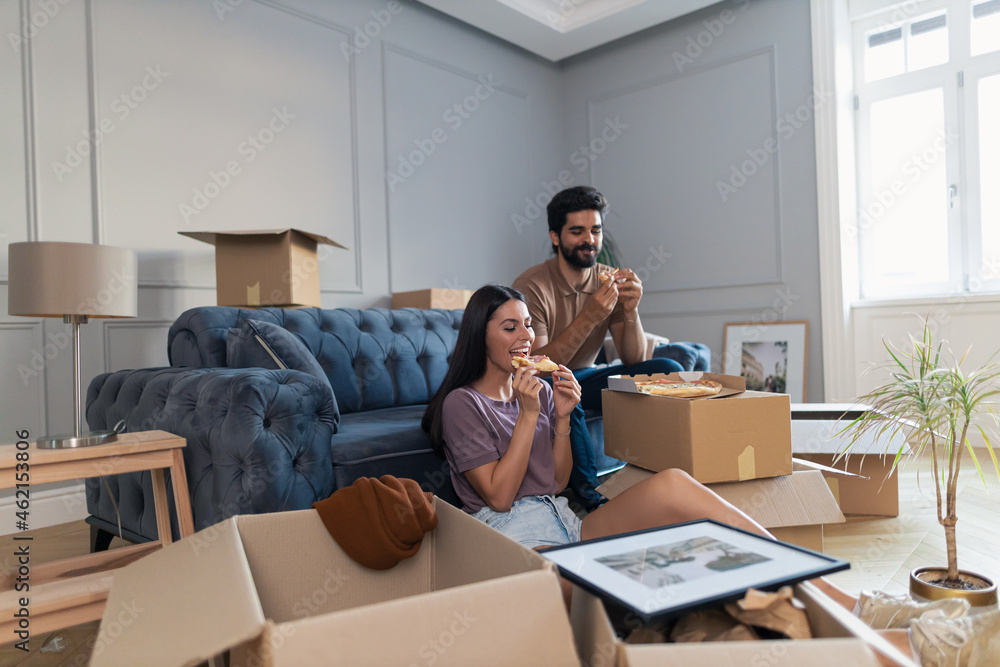 Young happy couple having pizza for lunch after relocating into a new home. Young happy couple having pizza for lunch after relocating into a new home.