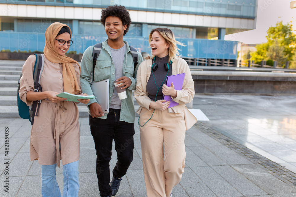 Fototapeta premium Group of diverse students outside smiling together and walking