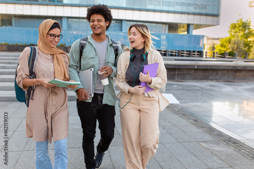 Group of diverse students outside smiling together and walking