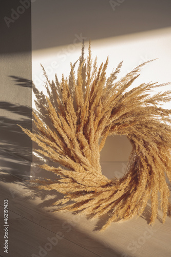 Pampas grass wreath fall interior decotarion in cottagecore style on the floor in sunlight. photo