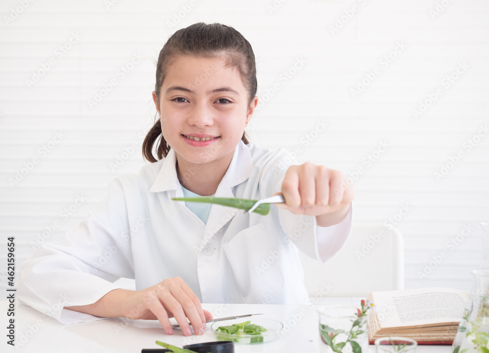 Little girl scientist showing aloe vera to camera and learning chemistry in school laboratory. Educational concept. Early development of children. Little girl scientist showing aloe vera to camera and learning chemistry in school laboratory. Educational concept. Early development of children.