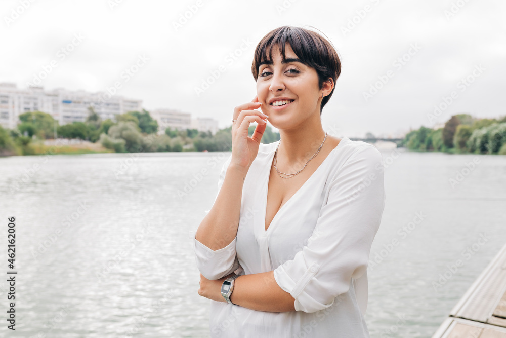 Beautiful woman with short hair standing by lake Beautiful woman with short hair standing by lake