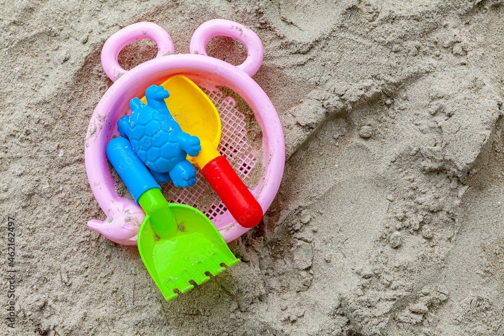 Plastic children ' s toys on the beach sand Plastic children ' s toys on the beach sand