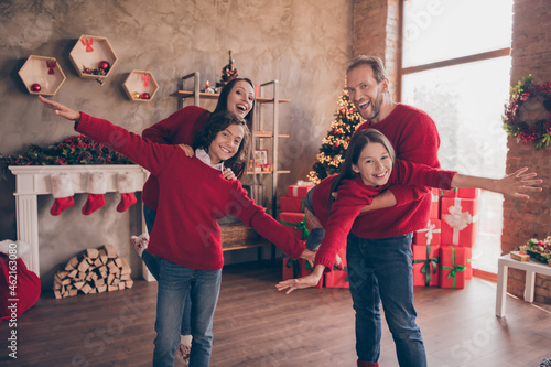 Photo of funny inspired carefree family have fun play kids fly plane pose in decorated x-mas home indoors