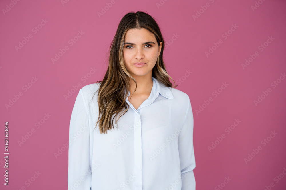Female business professional in front of pink wall Female business professional in front of pink wall