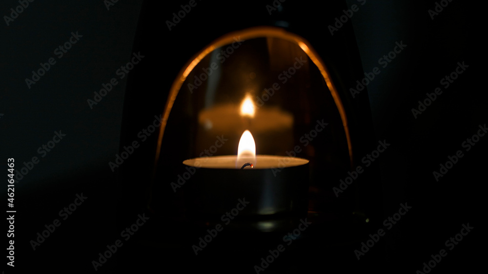 Candle lit in a candle holder with reflection in a dark room Candle lit in a candle holder with reflection in a dark room