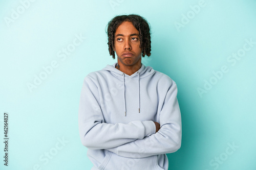 Young african american man isolated on blue background tired of a repetitive task.
