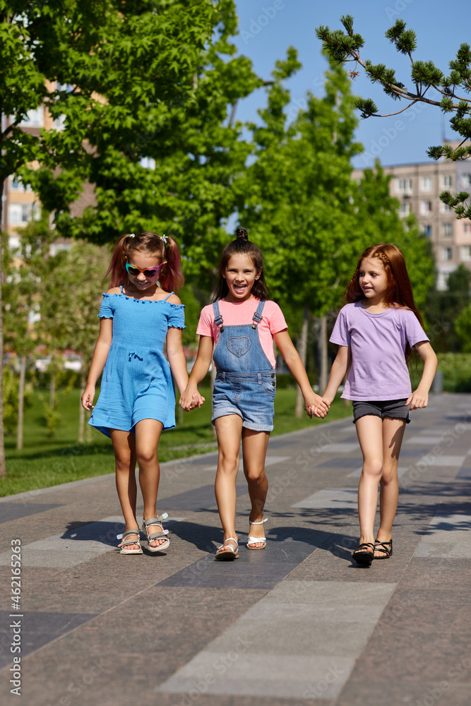 Fototapeta premium cute children girls playing together in the park