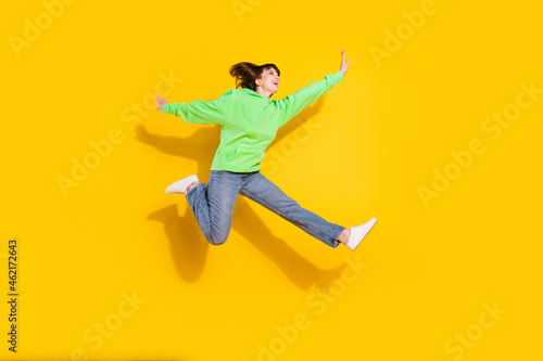 Full body photo of happy young woman good mood raise hands active isolated on yellow color background