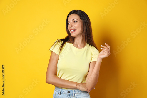 Portrait of beautiful woman on yellow background