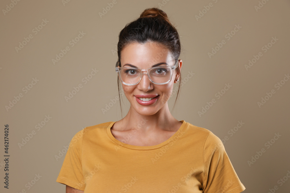 Beautiful woman in eyeglasses on beige background Beautiful woman in eyeglasses on beige background