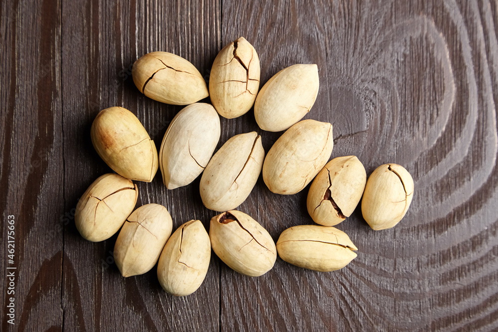 Obraz premium Pecan nuts into shell on wooden table