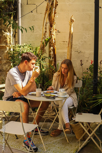 young couple having breakfast on the terrace of a bar