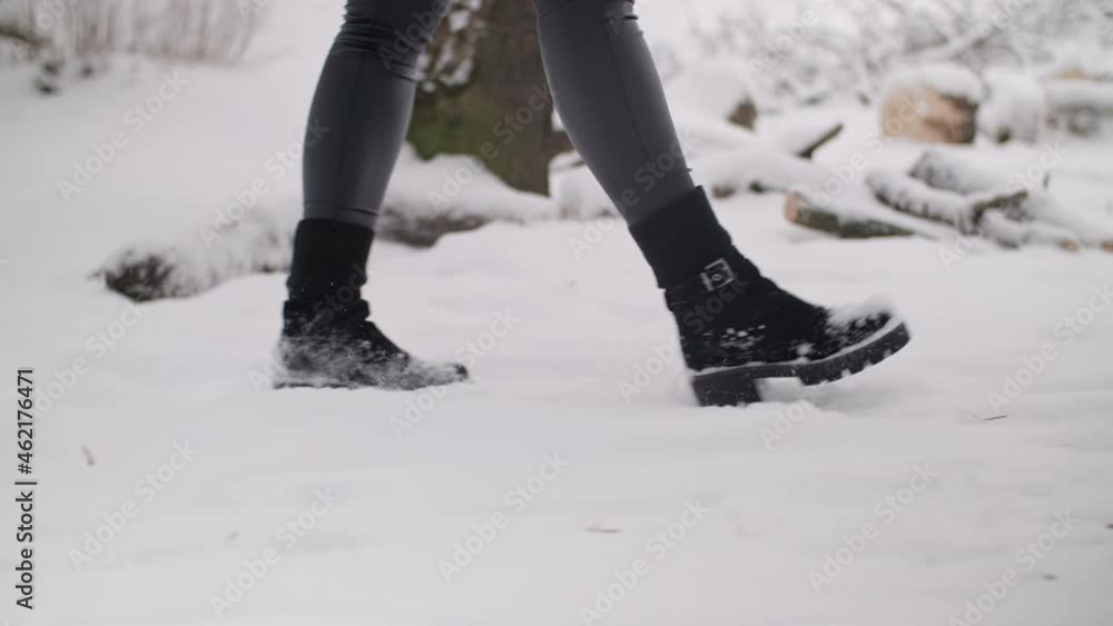 Woman walking in winter park enjoying nature. Tracking shot of female legs walks outdoors. Side view. Close-up in 4K, UHD Woman walking in winter park enjoying nature. Tracking shot of female legs walks outdoors. Side view. Close-up in 4K, UHD