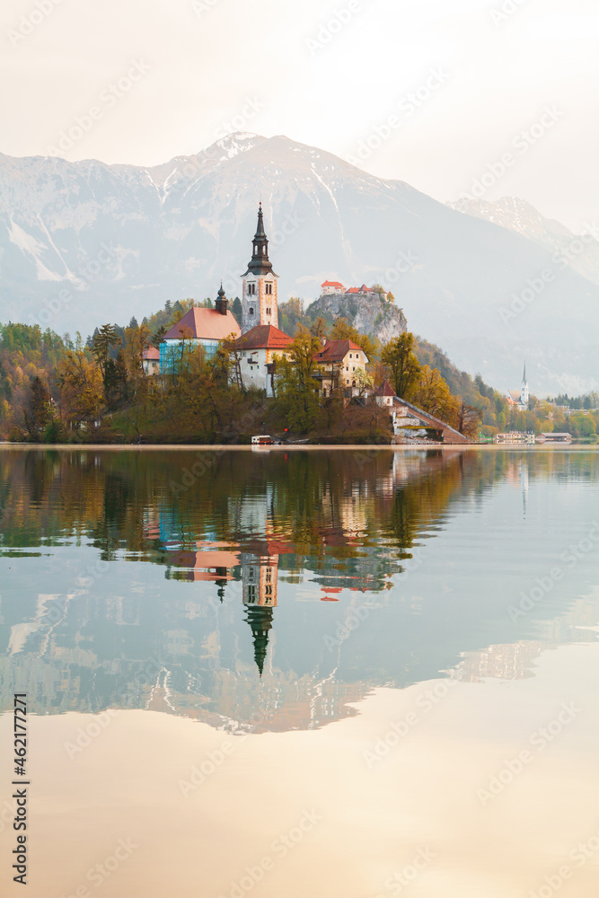 Beautiful cozy Lake Bled and the church on the island in the background with castle in the morning lights in the Julian Alps