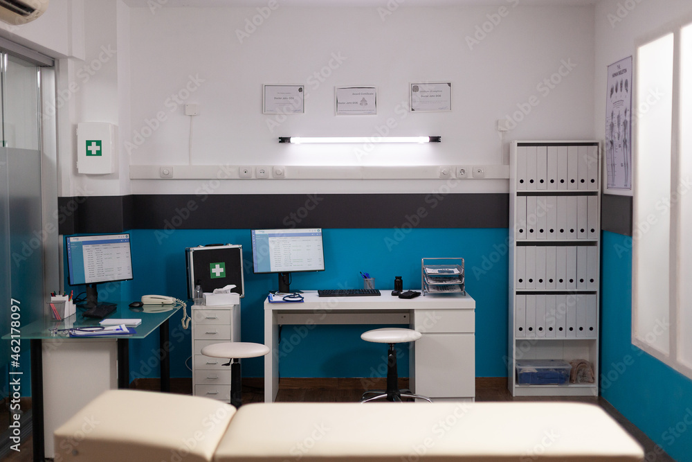 Empty hospital office with nobody in it having modern professional furniture. Medical documents on computer screeen during clinical consultation ready for patient treatment. Health care service Empty hospital office with nobody in it having modern professional furniture. Medical documents on computer screeen during clinical consultation ready for patient treatment. Health care service