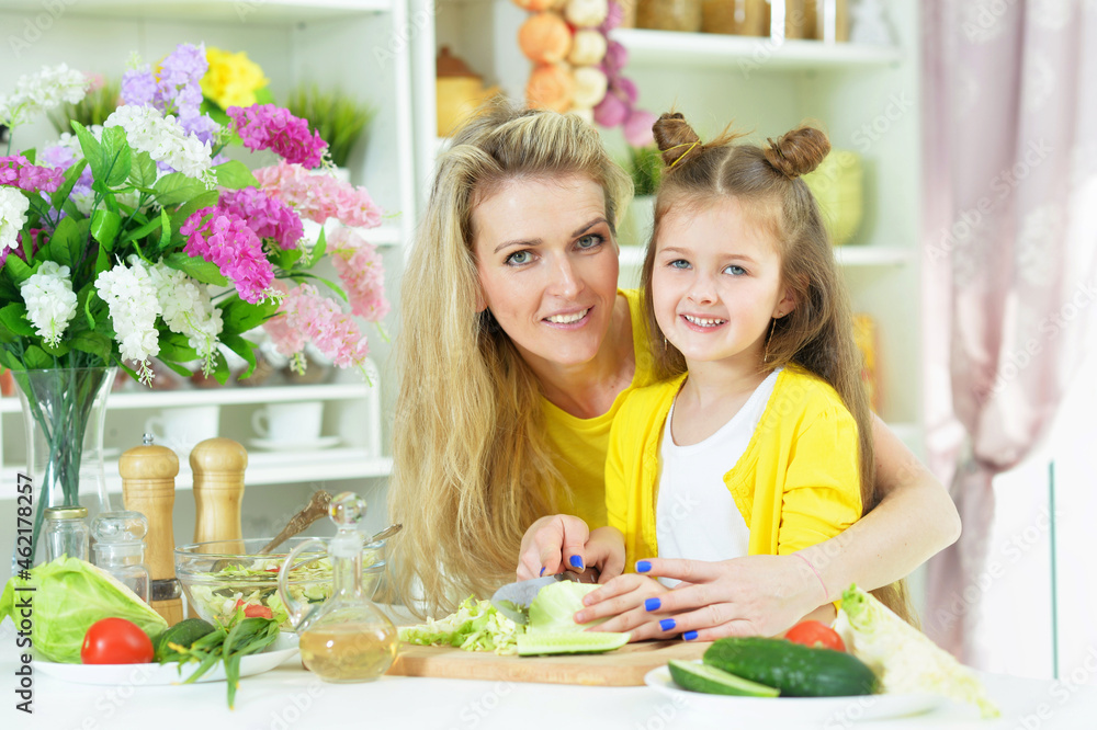 Portrait of smiling mother and daughter cooking together Portrait of smiling mother and daughter cooking together