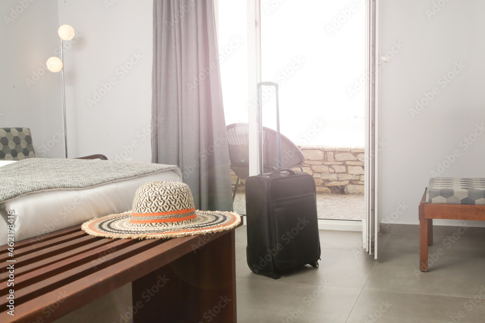 Luggage and straw hat in hotel room - obrazy, fototapety, plakaty 