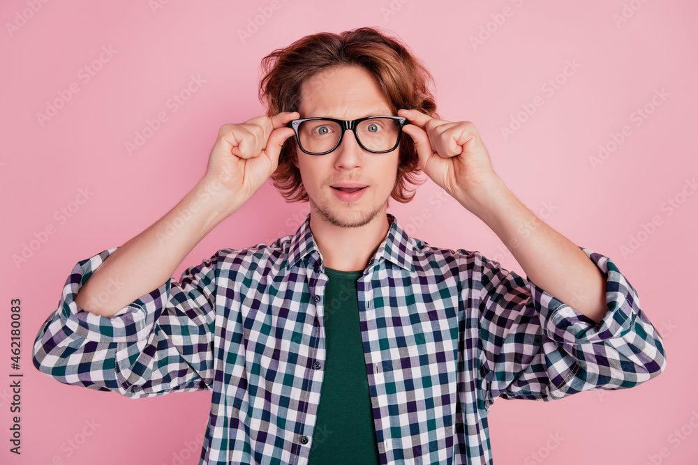 Close-up portrait of smart clever guy touching specs vision isolated over pink color pastel background Close-up portrait of smart clever guy touching specs vision isolated over pink color pastel background