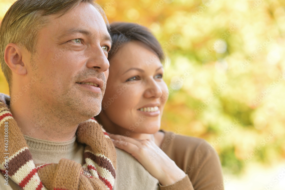 Happy couple posing in autumnal park outdoors Happy couple posing in autumnal park outdoors