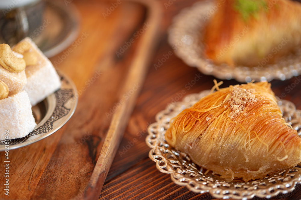 Turkish sweets on small plate on brown wooden background Turkish sweets on small plate on brown wooden background