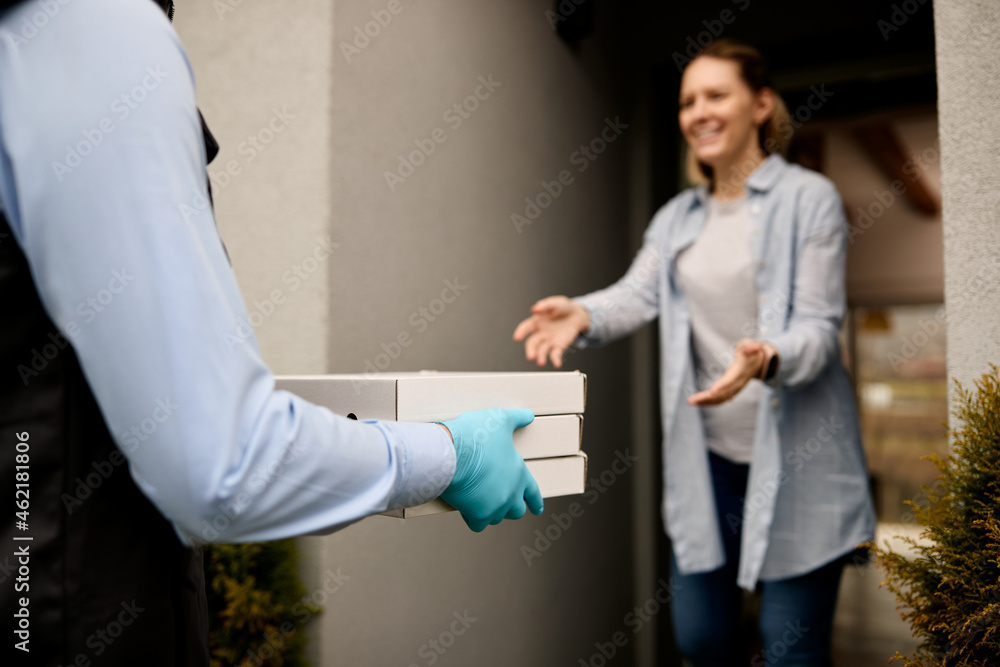 Close-up of food deliverer delivers pizza to customer's home address. Close-up of food deliverer delivers pizza to customer's home address.