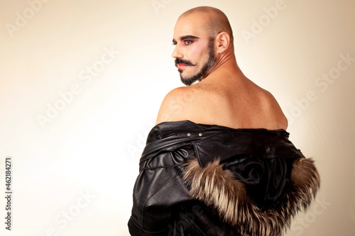 Bild auf Leinwand Portrait of bald made-up man with bare back wearing feather jacket