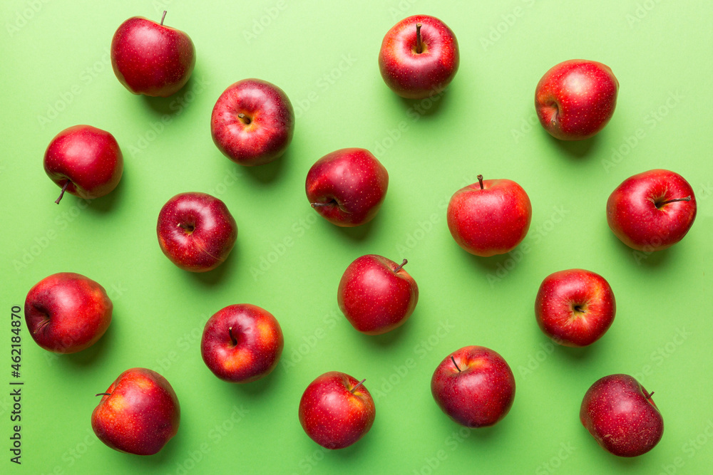 Many red apples on colored background, top view. Autumn pattern with fresh apple above view Many red apples on colored background, top view. Autumn pattern with fresh apple above view