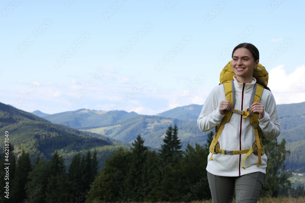 Tourist with backpack hiking through mountains, space for text