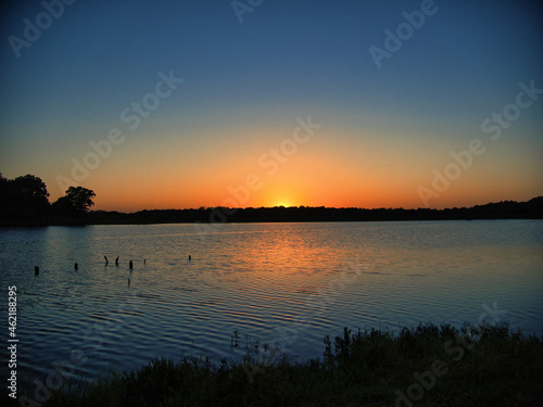 Horizontal shot of the sunset. The reflection of the sun on the water photo