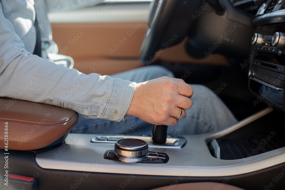 Close up of Caucasian man holding hand on gearshift.