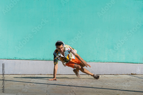 Casual man breakdancing and listening music with headphones photo