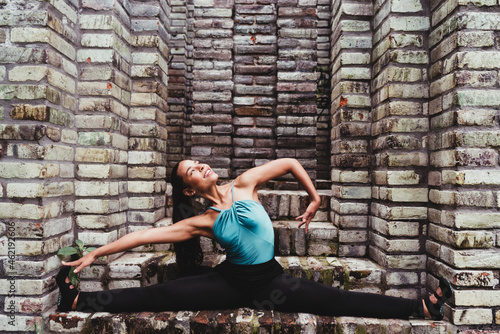 Smiling woman practicing yoga in stone structure photo