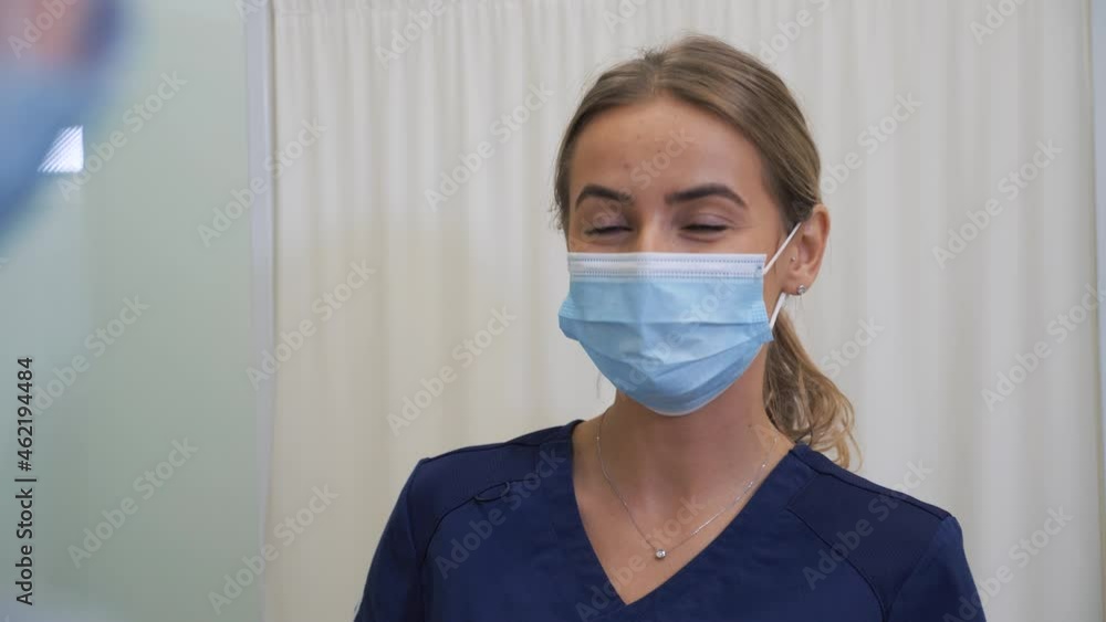 Female doctor in protective face mask and medical suits speaking with female patient during medical consultation in clinic. Coronavirus pandemic concept. Female doctor in protective face mask and medical suits speaking with female patient during medical consultation in clinic. Coronavirus pandemic concept.