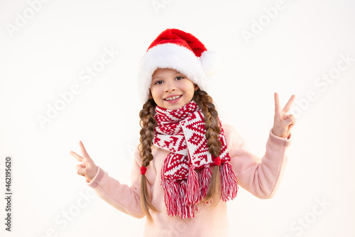 A little girl in a New Year's hat is very happy about the upcoming Christmas.