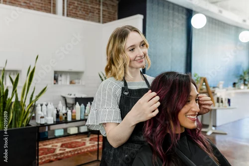 Obraz Hairstylist giving a haircut to a customer at a beauty salon