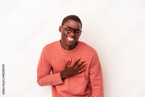 Young African American man isolated on white background laughs out loudly keeping hand on chest.
