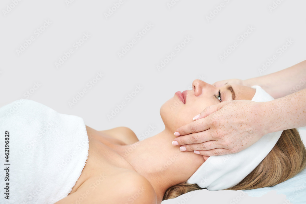 Face massage at spa salon. Doctor hands. Closeup view. High quality photo. Pretty female patient. Beauty treatment. Healthy skin procedure. Young woman head. Light background. Scrub rejuvenation