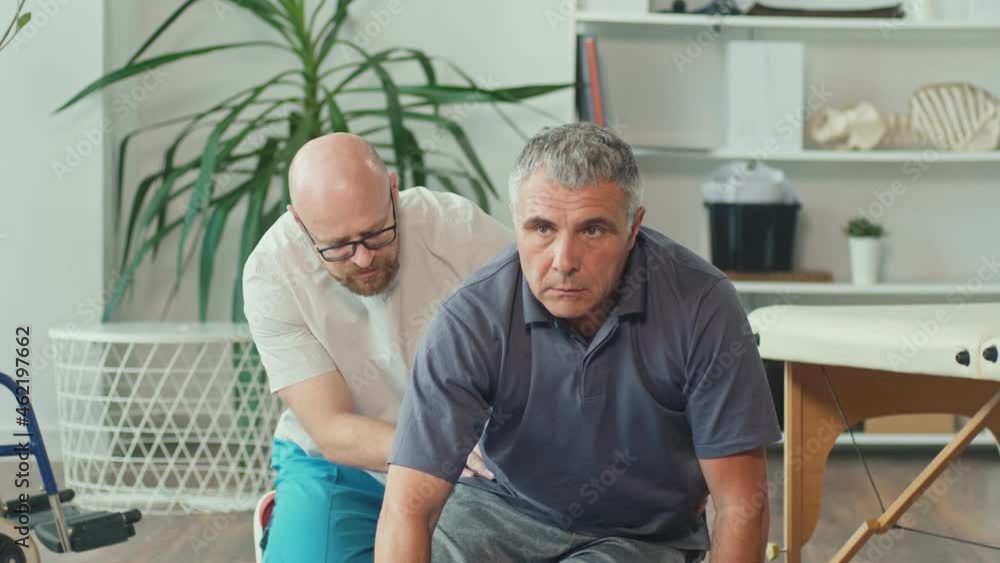 Professional Physiotherapist Working with a Patient a Brain Stroke in a Modern Rehabilitation Center. Damage to the Nervous System. Brain Hemorrhage. Elderly Health Support Concept. Professional Physiotherapist Working with a Patient a Brain Stroke in a Modern Rehabilitation Center. Damage to the Nervous System. Brain Hemorrhage. Elderly Health Support Concept.
